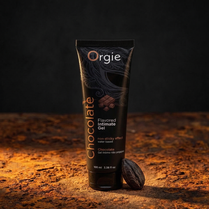 Tube of Orgie Chocolate flavored intimate gel on a textured surface with a dark background