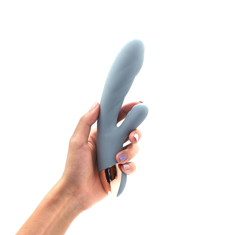 The Crescent luxury rabbit vibrator by Sigh. . . in Arona Blue. A dual-action silicone vibrator featuring a sleek, ergonomic design for G-spot and clitoral stimulation, shown in a soft blue-grey hue.