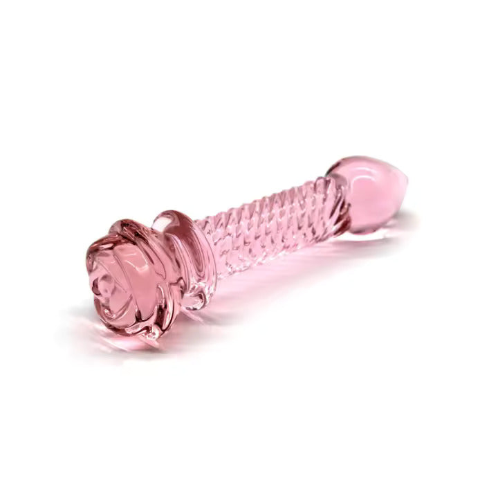 The Floret glass sculpture, a clear hand-blown borosilicate glass dildo with a textured rose-shaped head and a smooth weighted shaft.