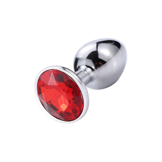 The Prism weighted steel sensory plug in Garnet red, featuring a tapered metal body and a light-refracting crystal base.